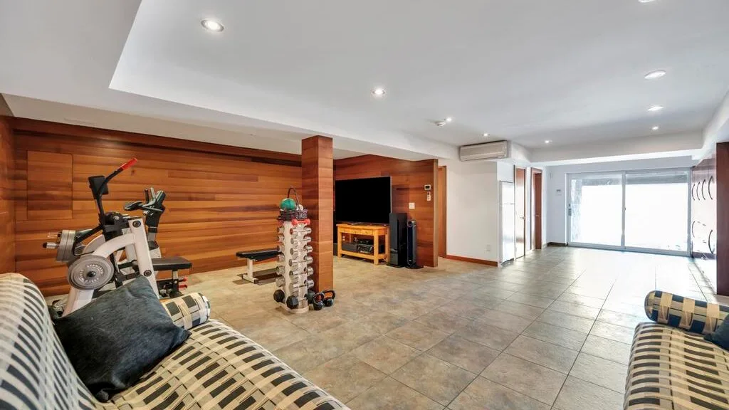 A spacious exercise room with fitness equipment and seating.