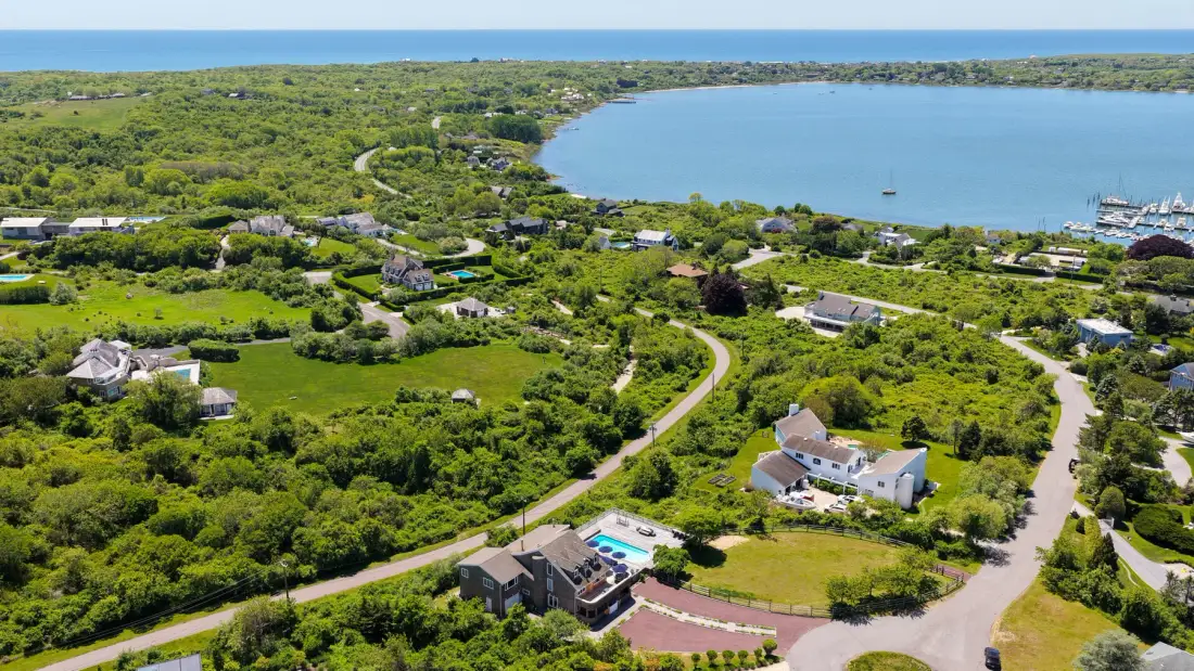 Aerial view of a coastal neighborhood with winding roads and greenery.