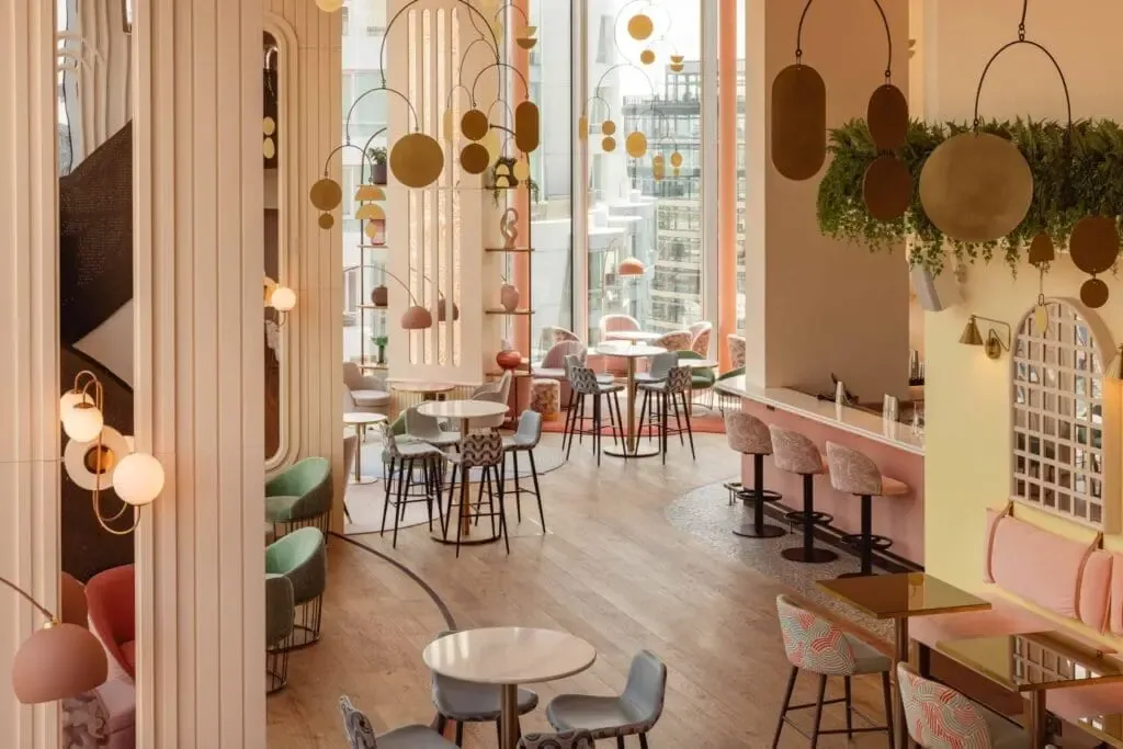 Restaurant interior with tables and large windows.