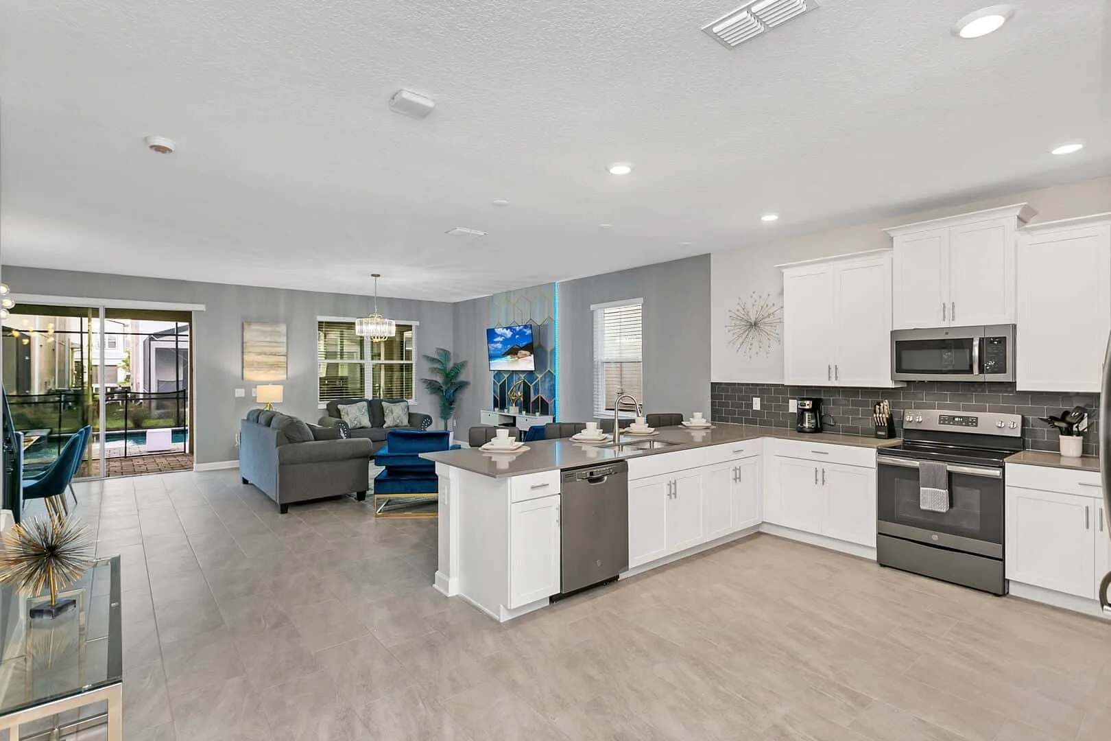 Cocina y sala de estar de concepto abierto, con una isla blanca y asientos.