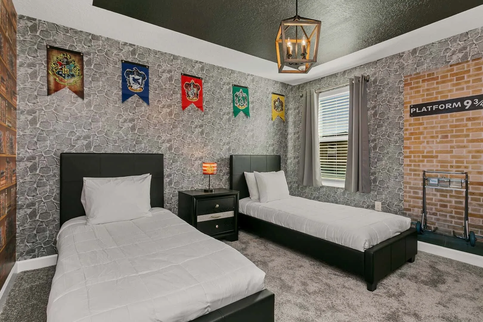 Un dormitorio con dos camas individuales, paredes estampadas y una ventana.