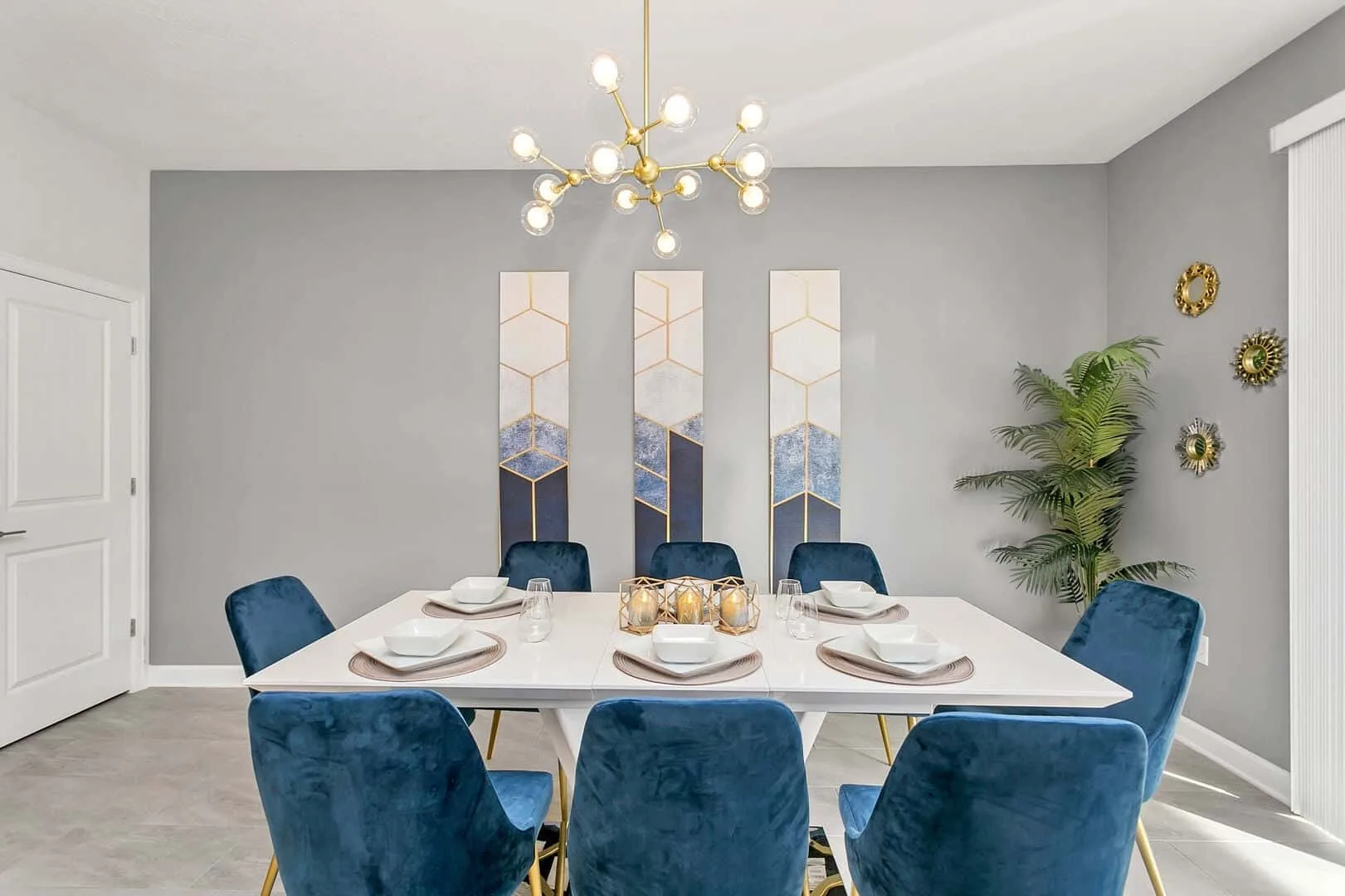 Un comedor con una mesa larga, asientos azules y arte en la pared.