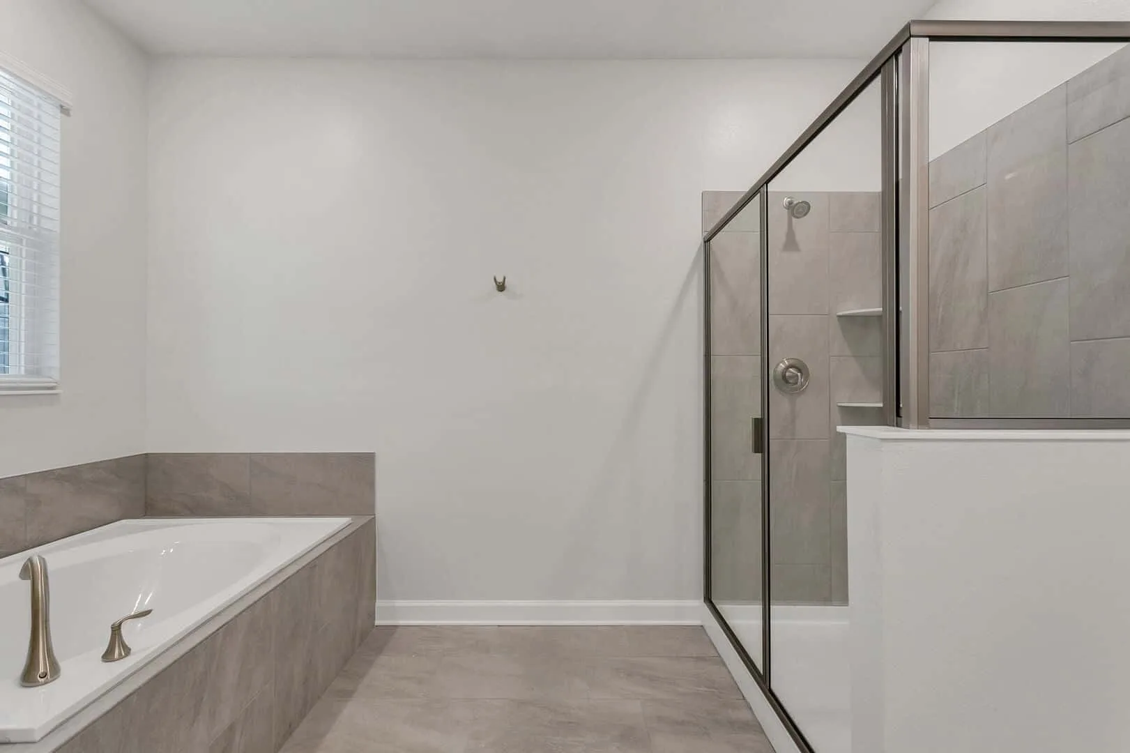 Un baño con bañera y una ducha con paneles de vidrio.