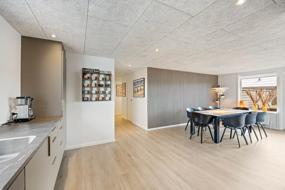 Cocina y comedor abiertos con una mesa y sillas junto a la encimera.