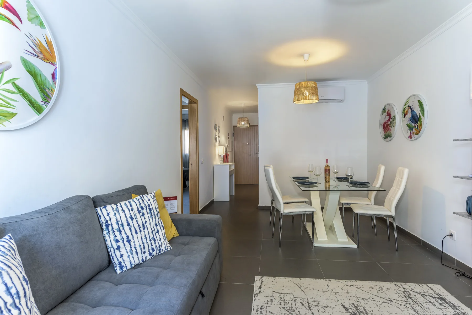 A living and dining area with gray seating and a table.