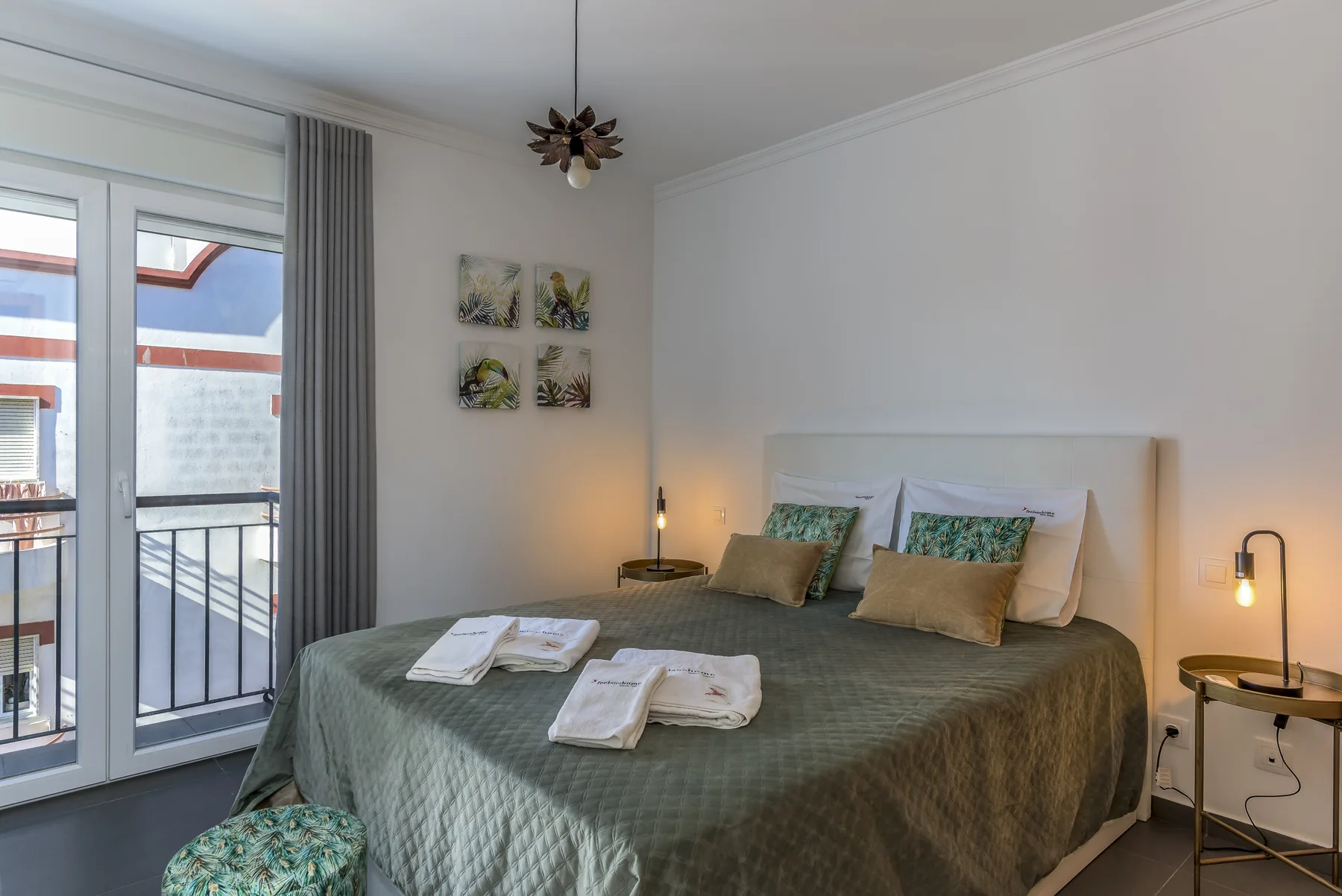 A bedroom with a large bed, bedside tables, and a balcony door.