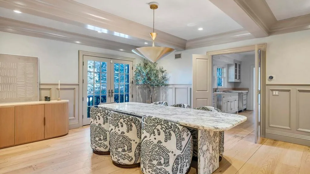 Una cocina luminosa con una gran isla de piedra y gabinetes.