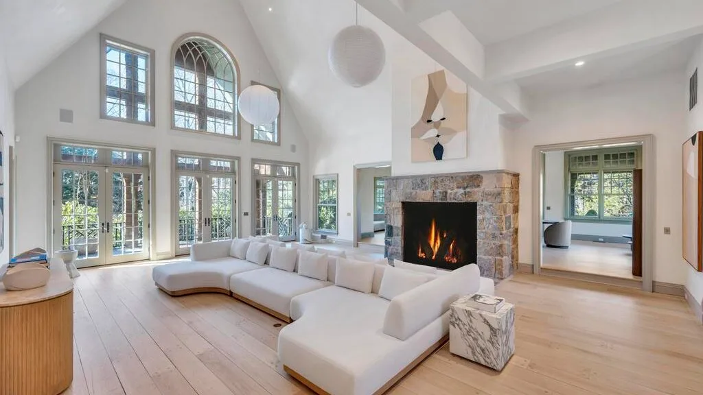 Una sala luminosa con chimenea y grandes ventanas.