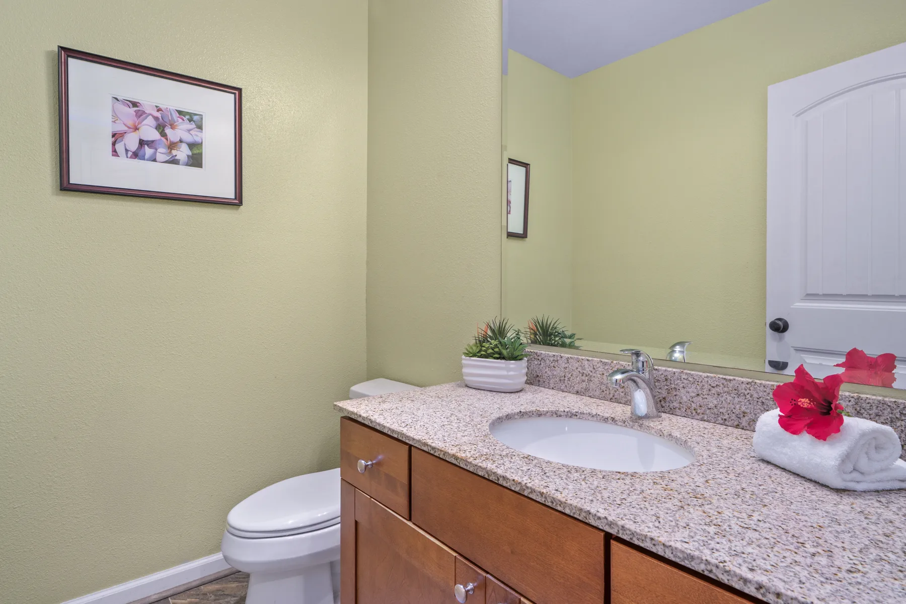Un tocador de baño con lavabo, espejo e inodoro.