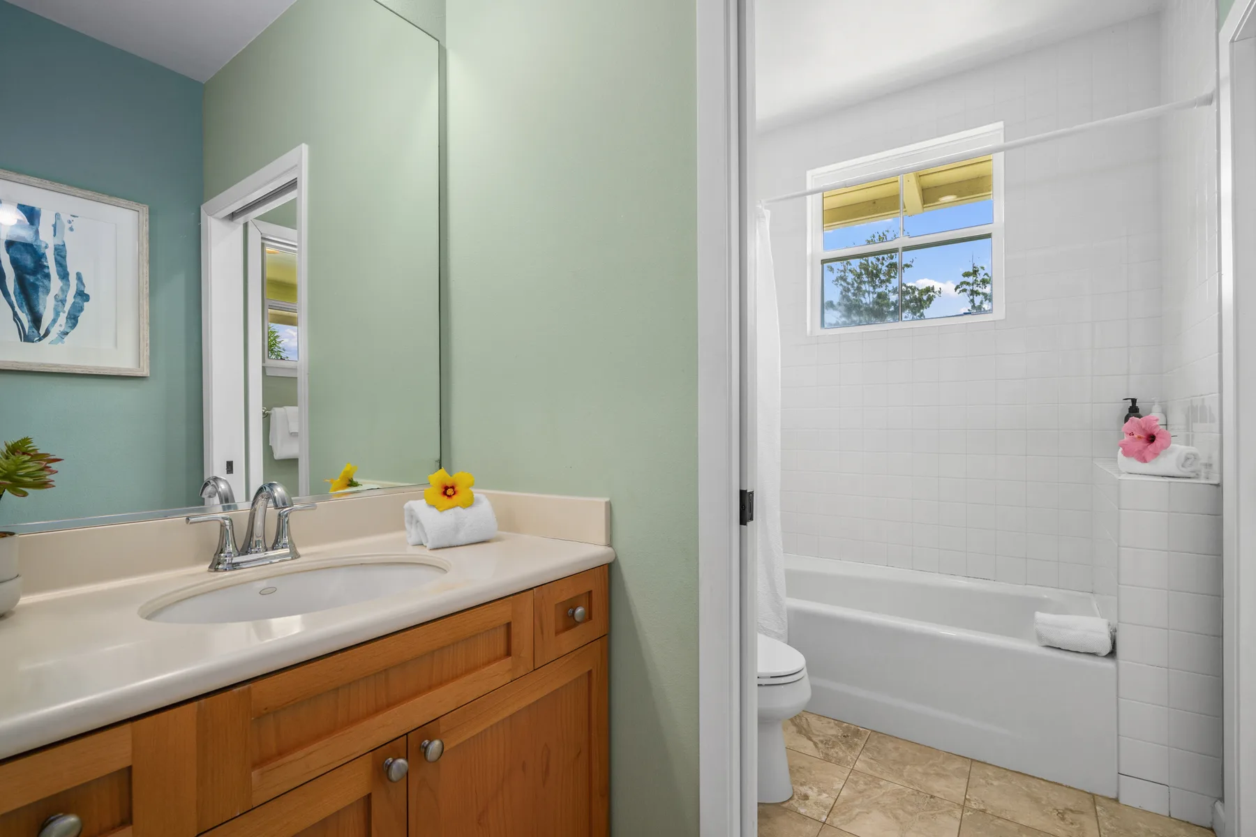 Un lavabo de baño está junto a una bañera blanca y paredes de azulejos.