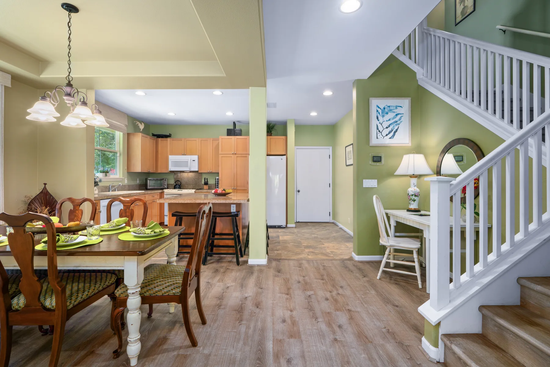 Un comedor de planta abierta y una cocina están junto a una escalera.