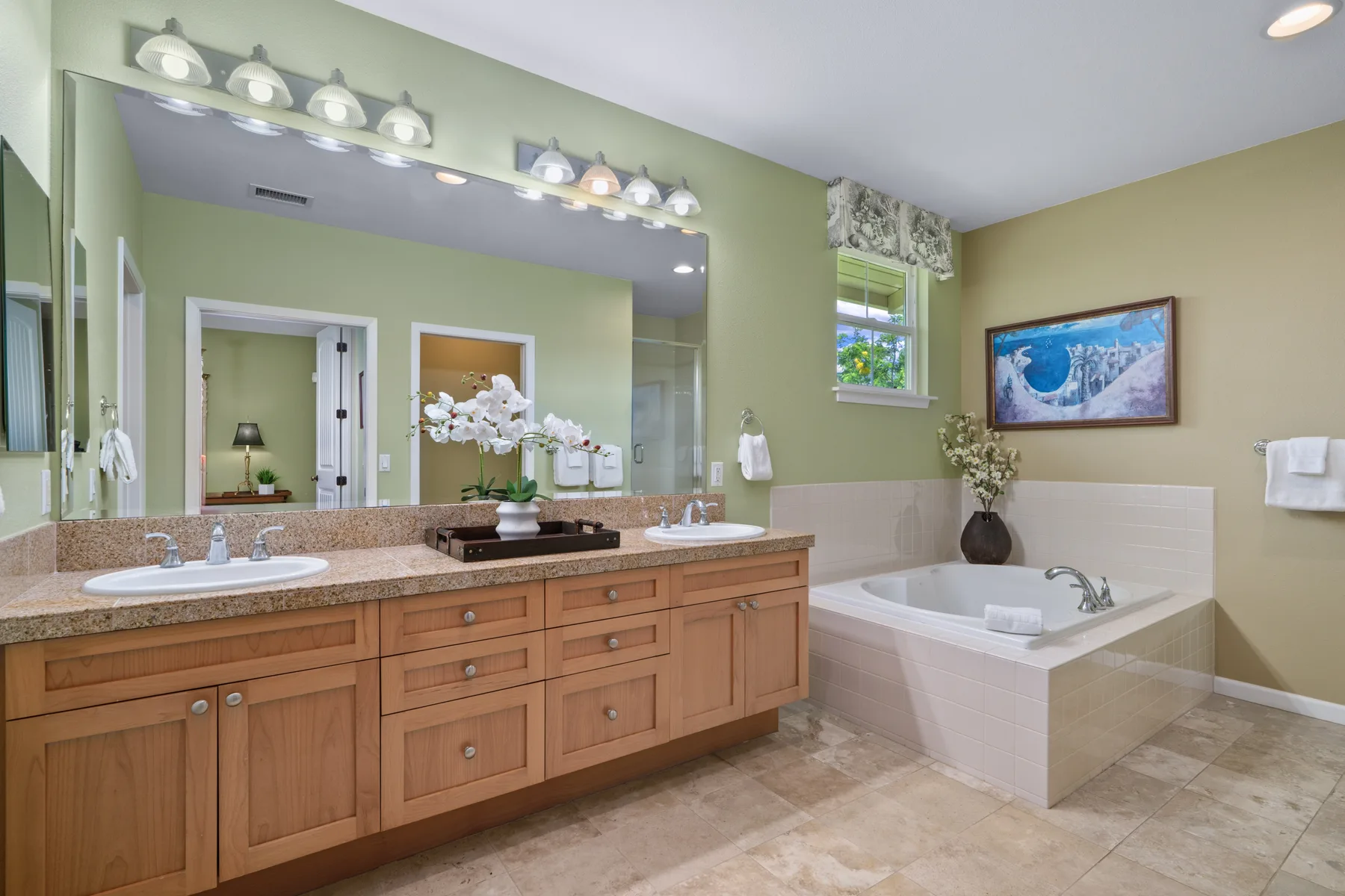 Un baño con lavabo doble, espejo grande y bañera.
