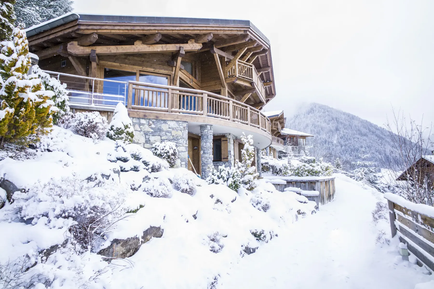 El exterior de un chalet da a una ladera nevada y un paisaje de montaña.