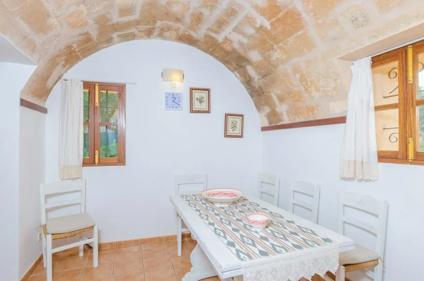 Un comedor con una mesa larga bajo un arco de piedra.
