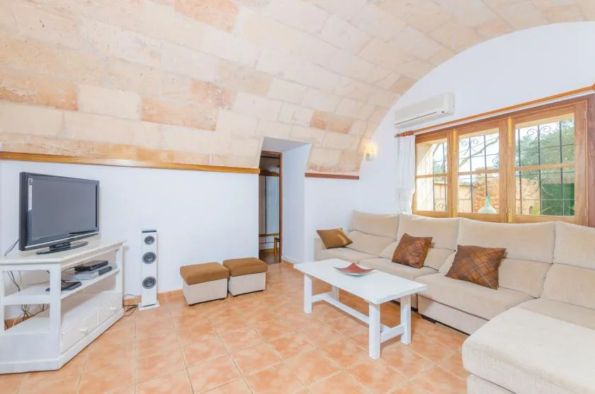 Una sala de estar con asientos, un televisor y una mesa de centro.