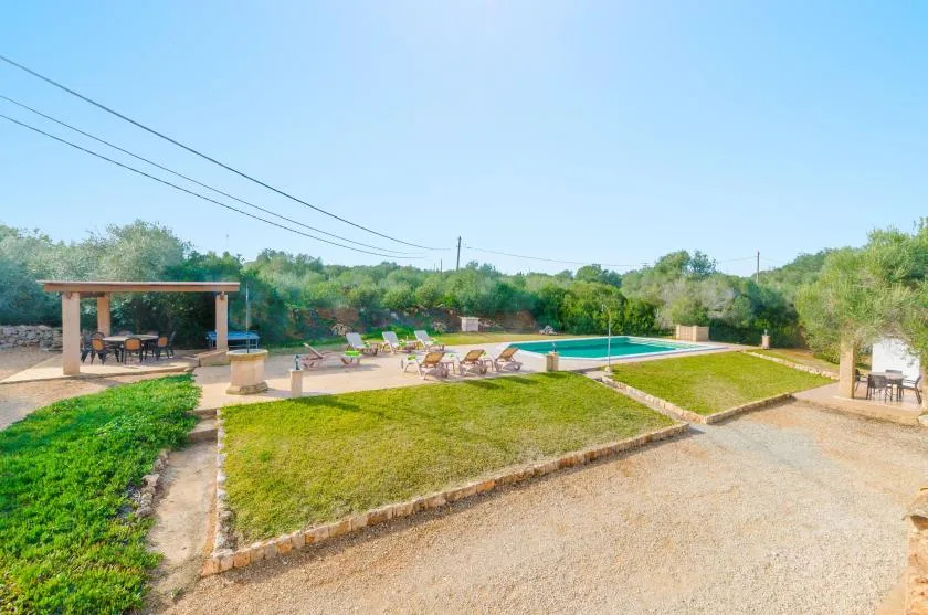 Una zona de piscina al aire libre con asientos y un patio cubierto.