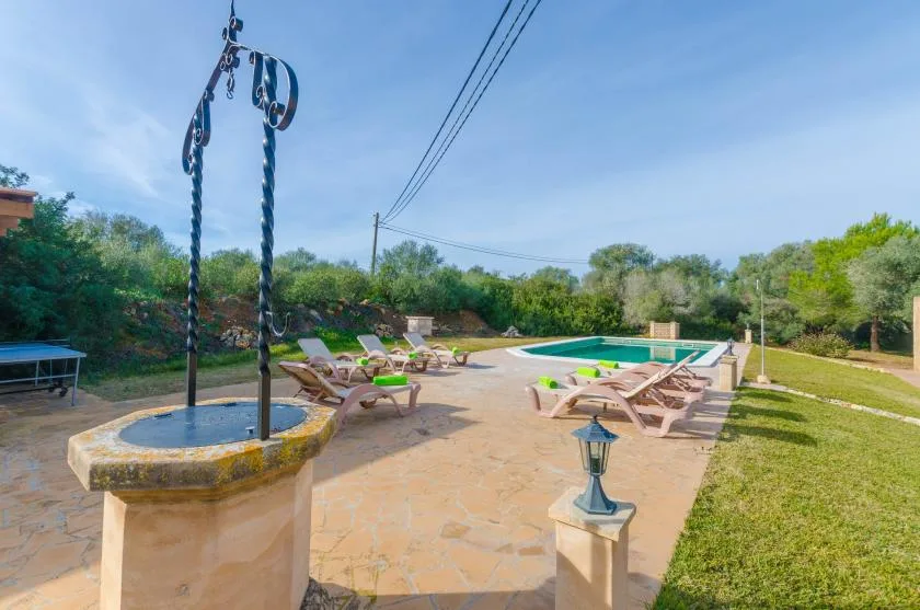 Una piscina al aire libre está rodeada de tumbonas y un patio pavimentado.