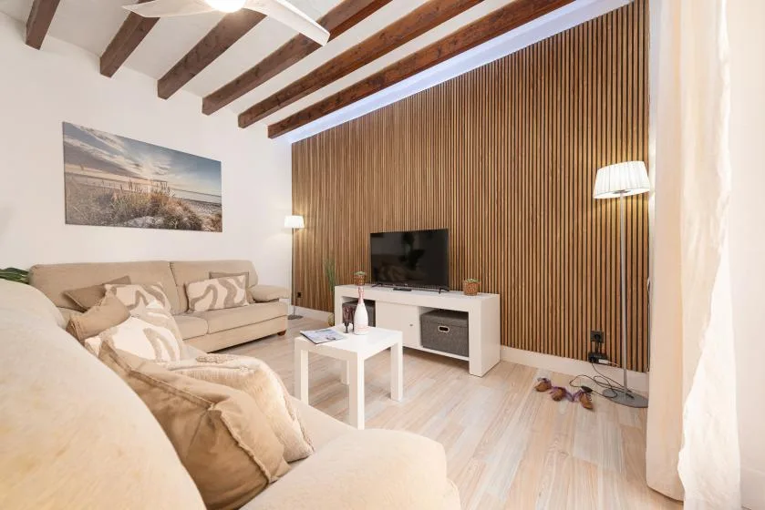 A living room with seating, a television, and a white coffee table.