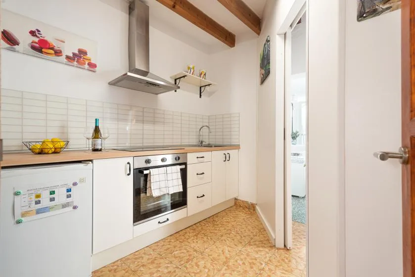 A bright kitchen with light cabinets, a tiled backsplash, and an oven.