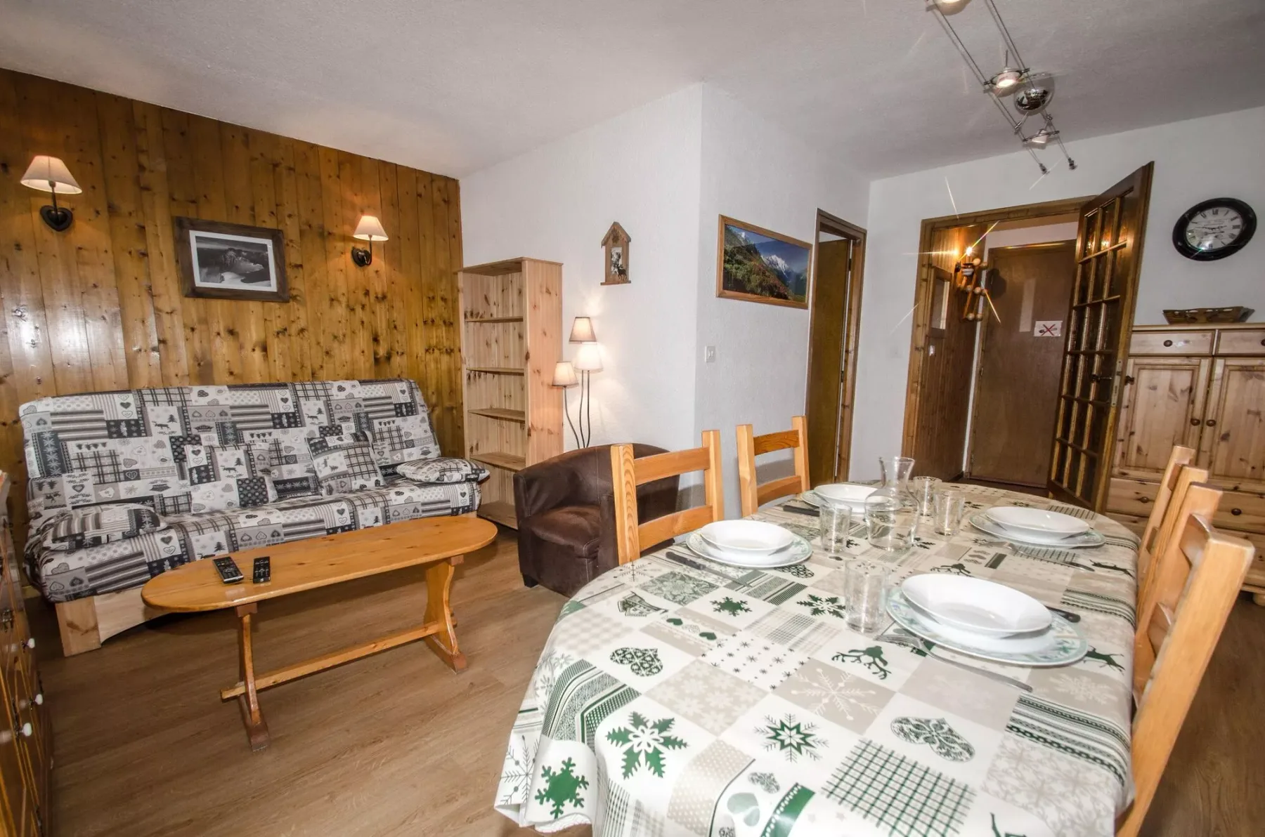 A dining area with a table set with plates beside a seating area.