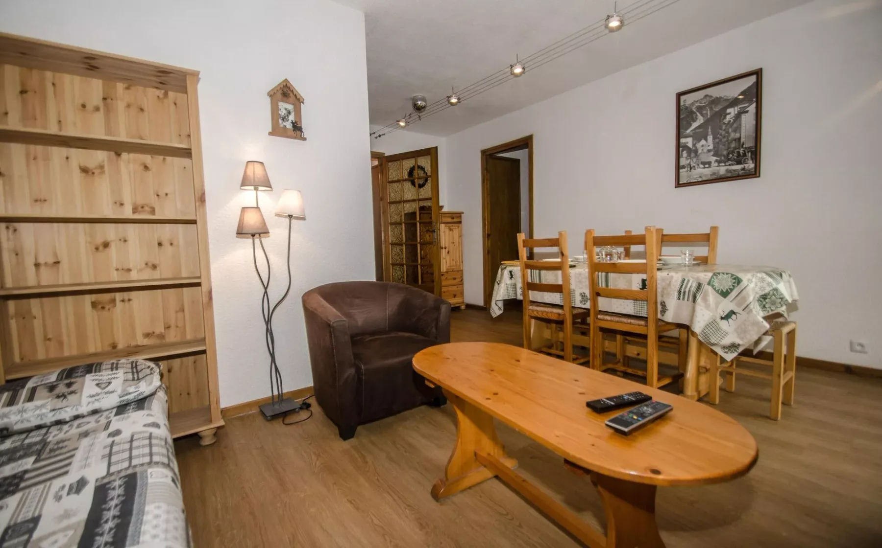 A living and dining room with wooden seating and a low coffee table.