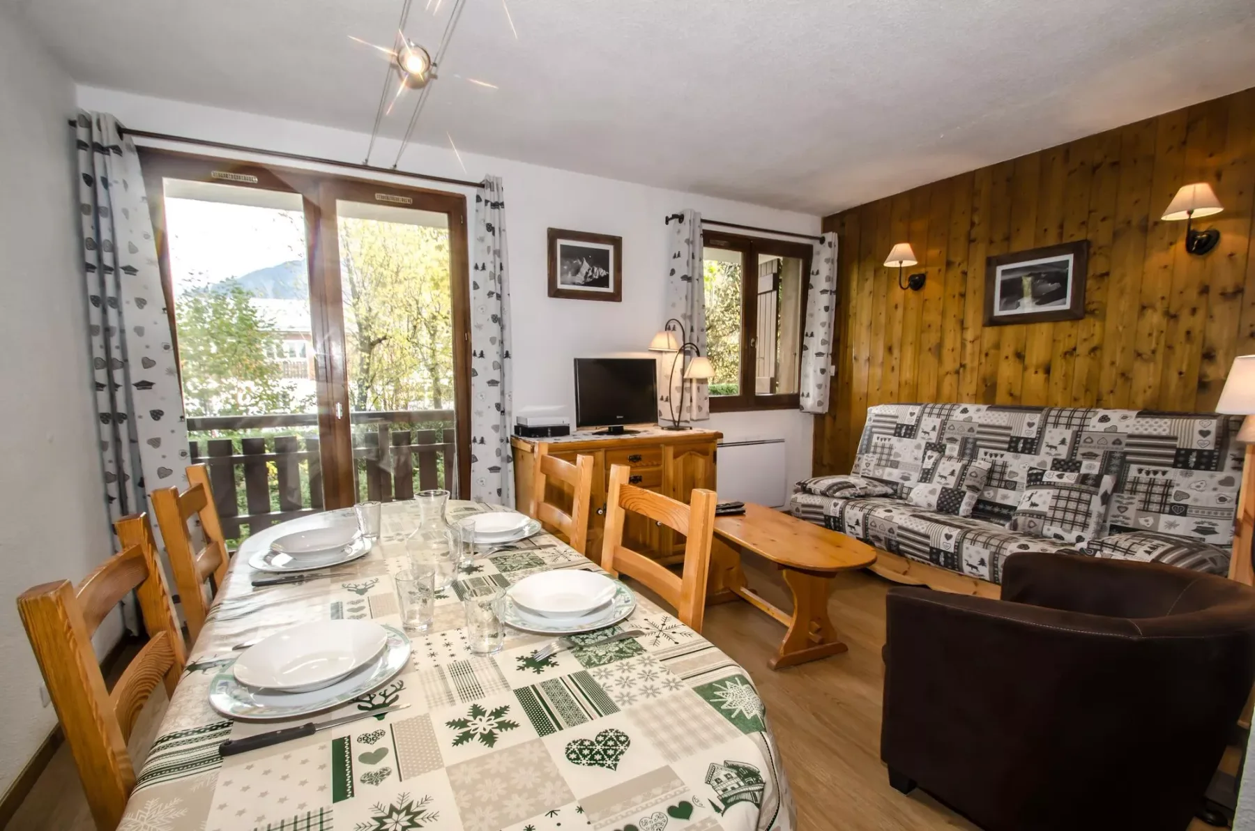 A combined dining and living room with a set dining table and patterned seating.