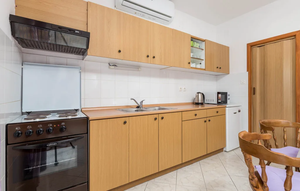 A kitchen with wooden cabinets, a stove, and a sink.