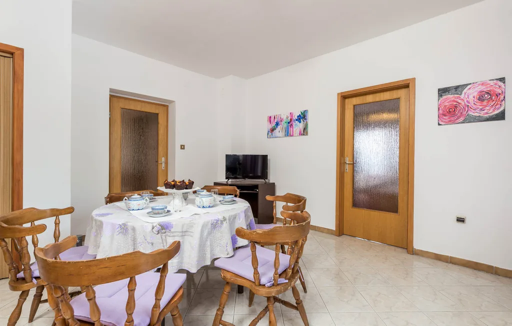 A dining area with a table set with dishes and wooden seating.