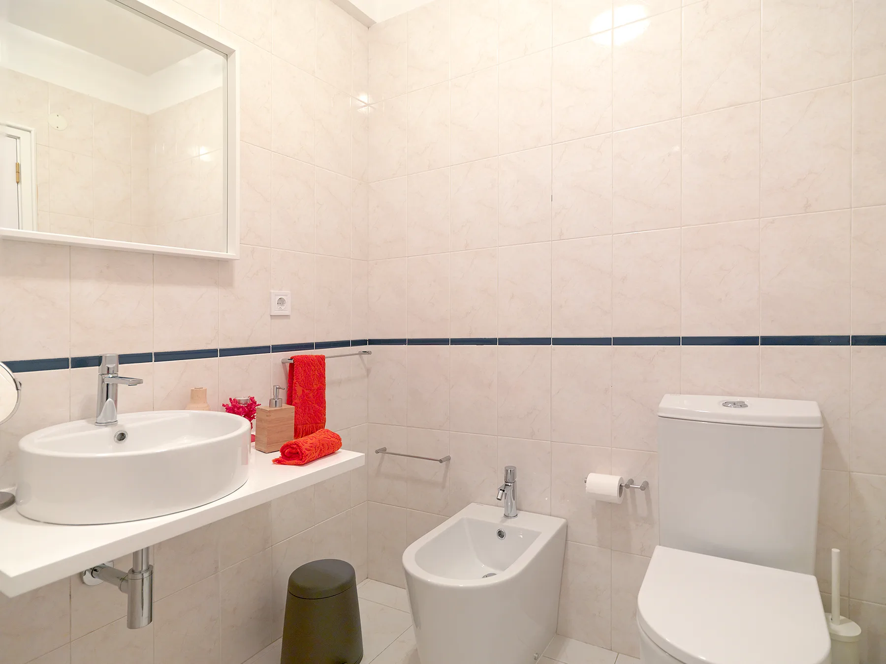 Un baño alicatado con lavabo, inodoro y bidé.