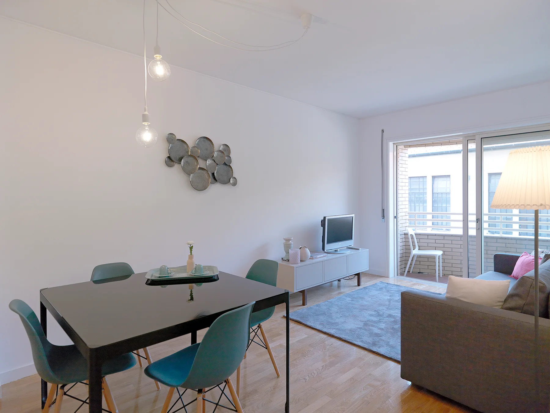 Sala de estar y comedor con una mesa, asientos y un televisor.