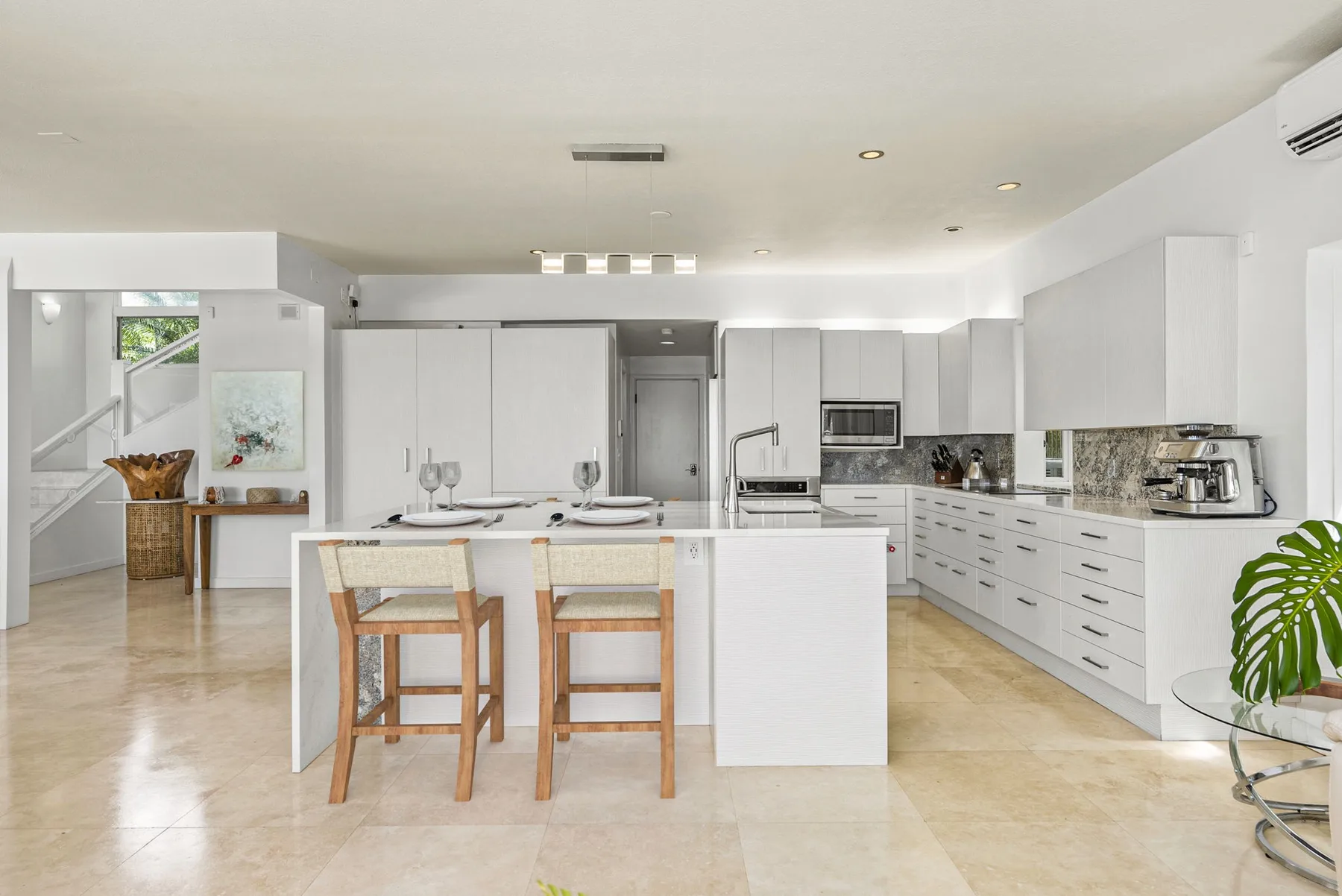 A bright modern kitchen with a central island and dining seating.