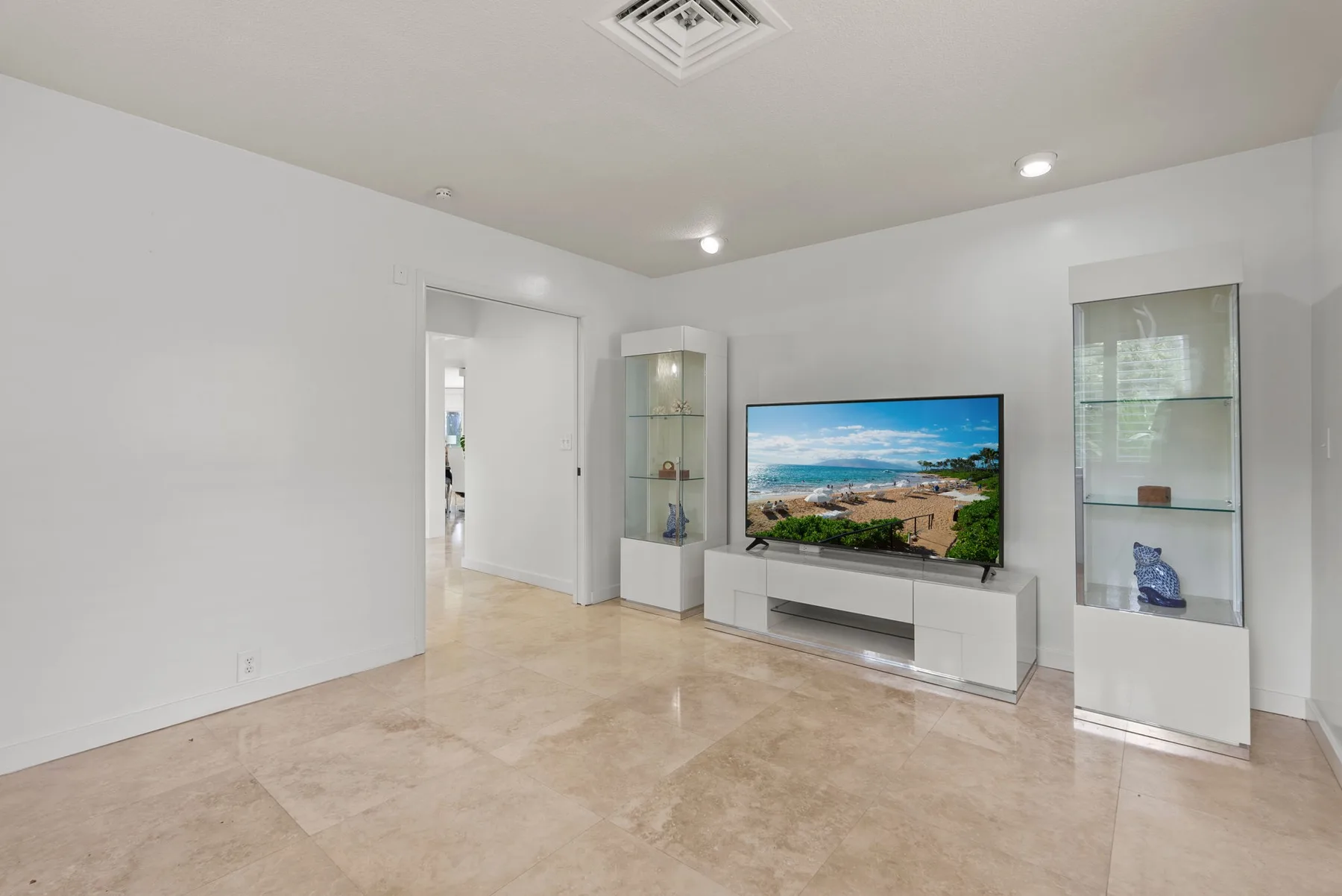 A bright living room with a television on a low media console.