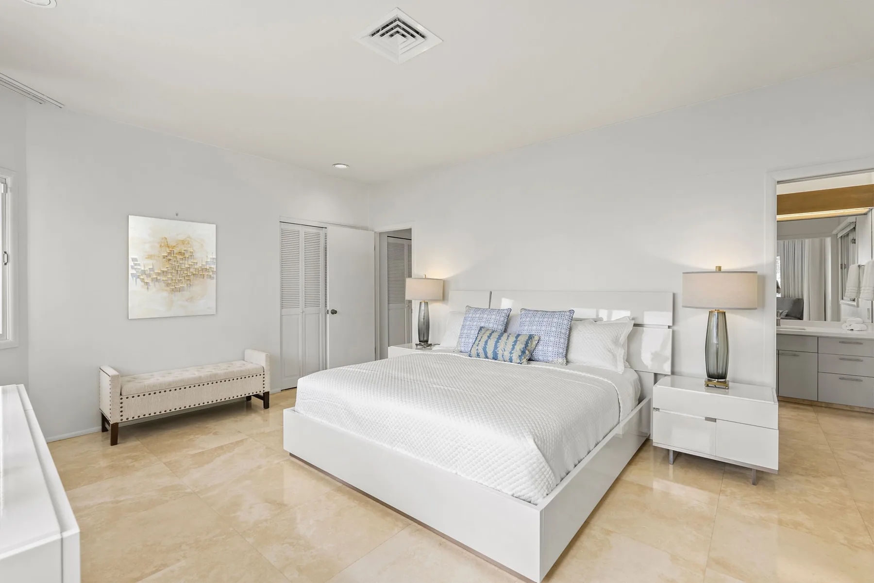 A bright bedroom with a large bed and matching bedside tables.