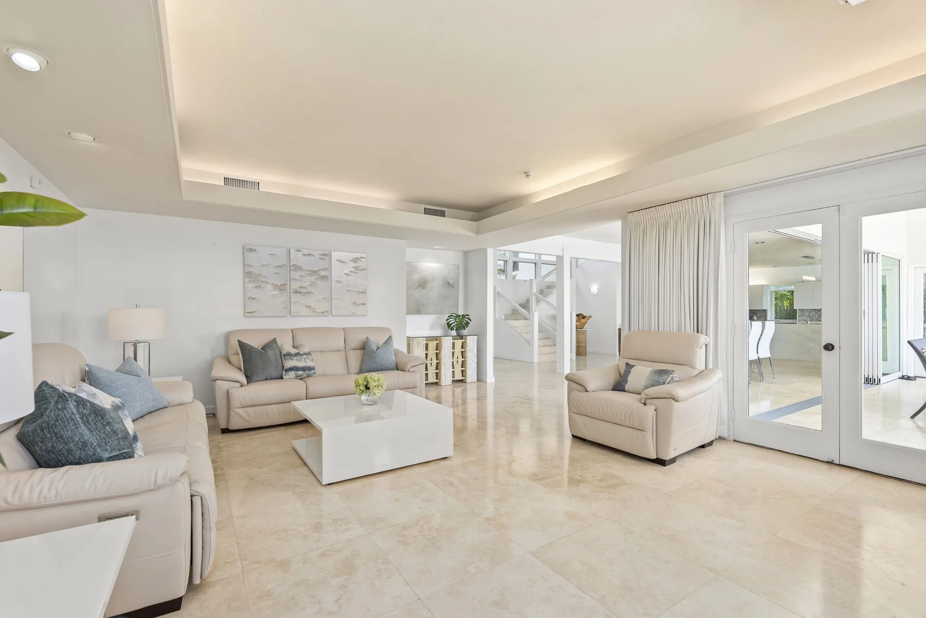 A bright living room with seating around a low white coffee table.