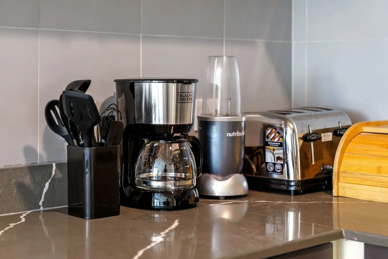 Kitchen counter with a coffee maker, blender, toaster, and utensil holder.