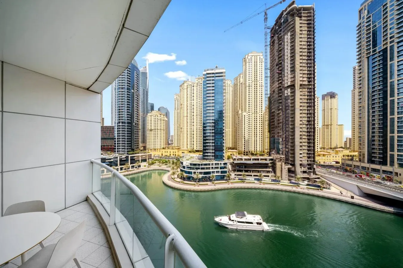 A balcony overlooks a canal and a cluster of high-rise buildings.