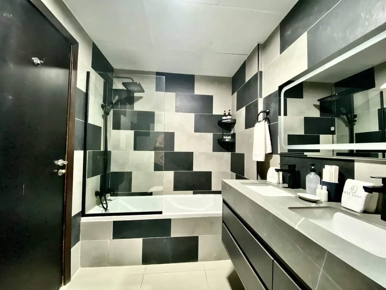 A modern bathroom with a bathtub, shower, and sink vanity.