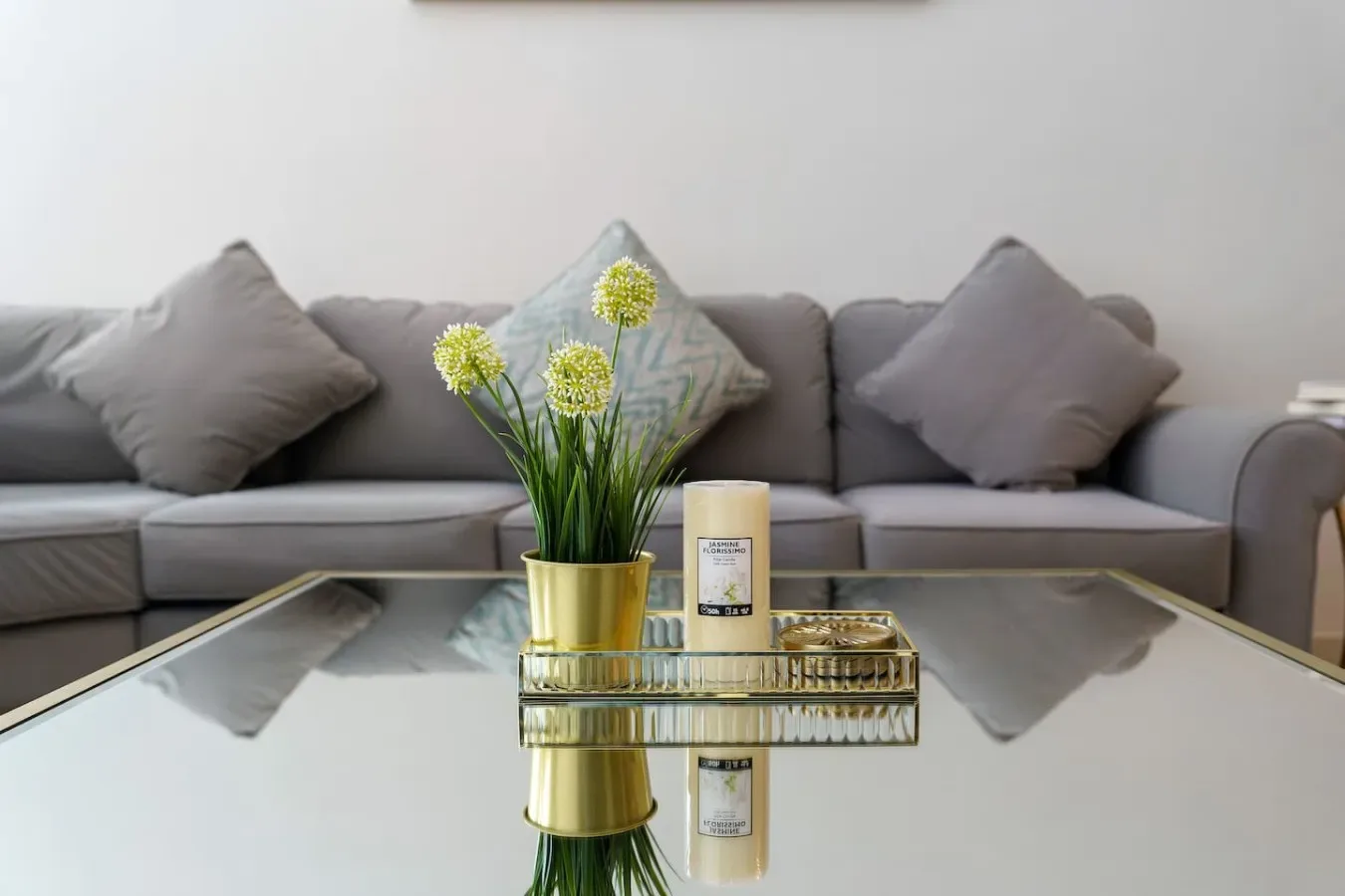 Living room seating faces a glass coffee table with a flower arrangement.