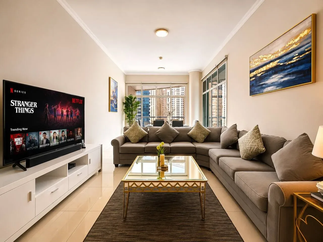 Una sala de estar con asientos en forma de L, una mesa de centro y un televisor.