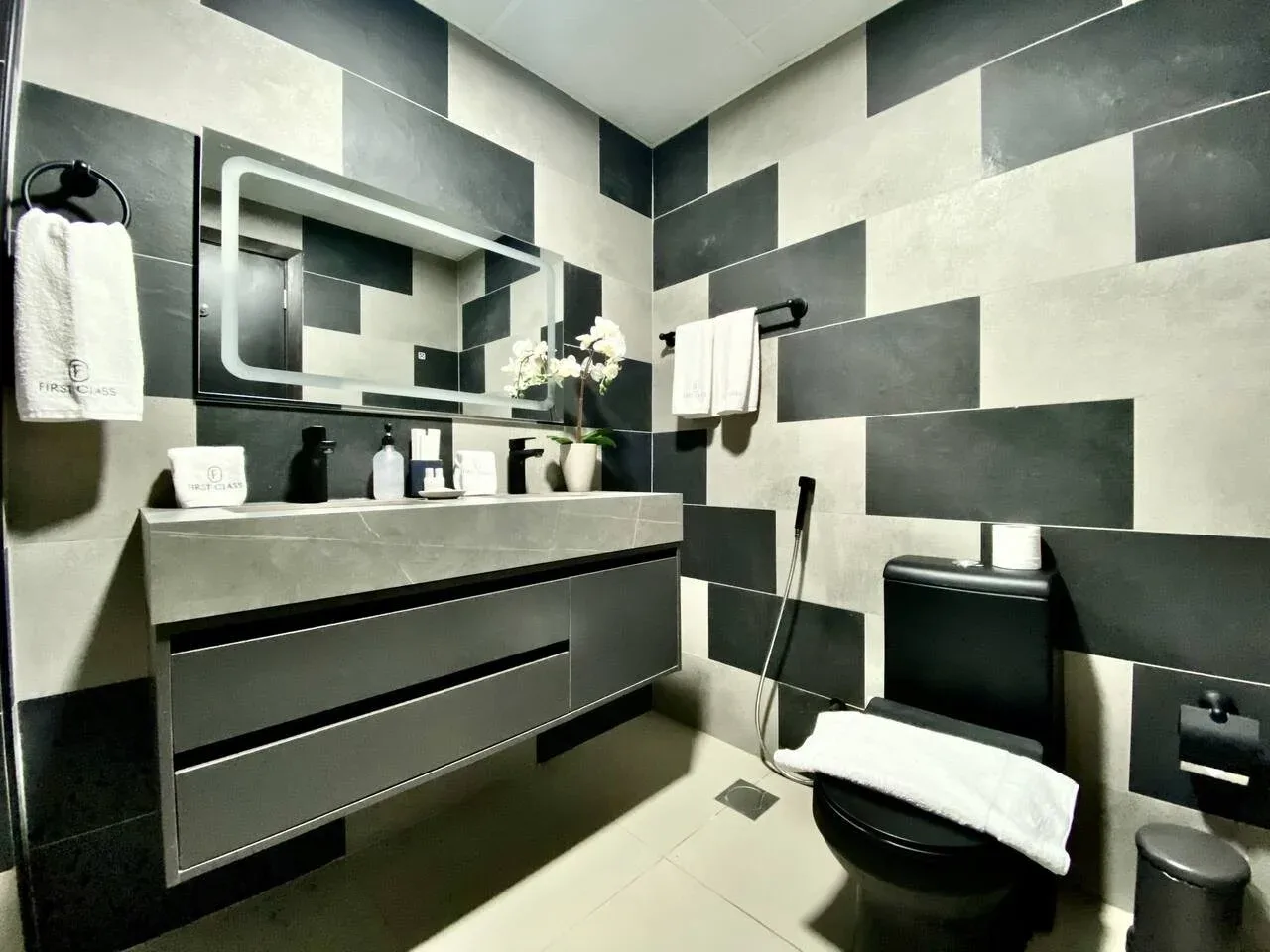 A modern bathroom with a vanity, mirror, and toilet.