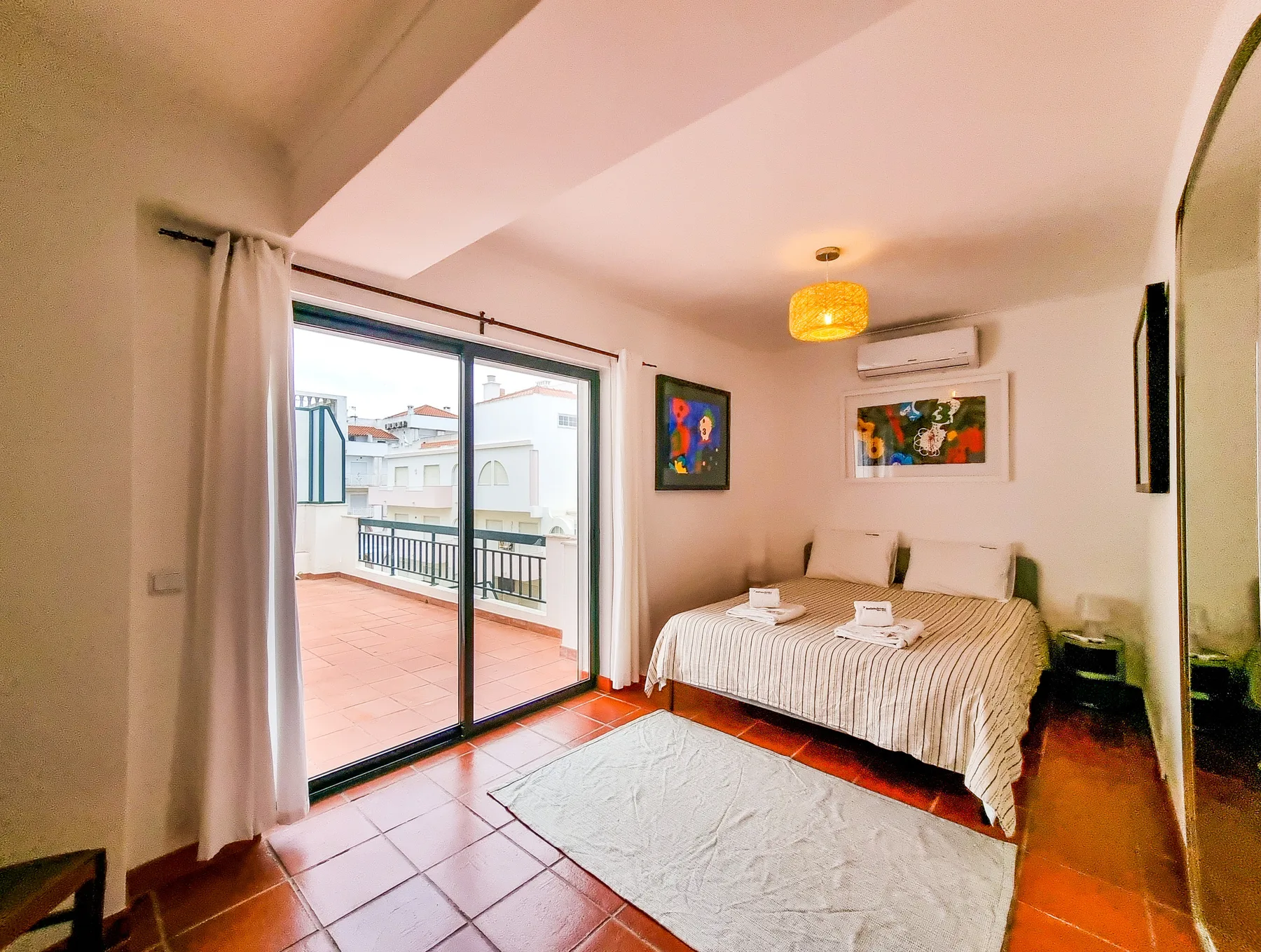 A bedroom with a bed and sliding glass doors opening onto a balcony.