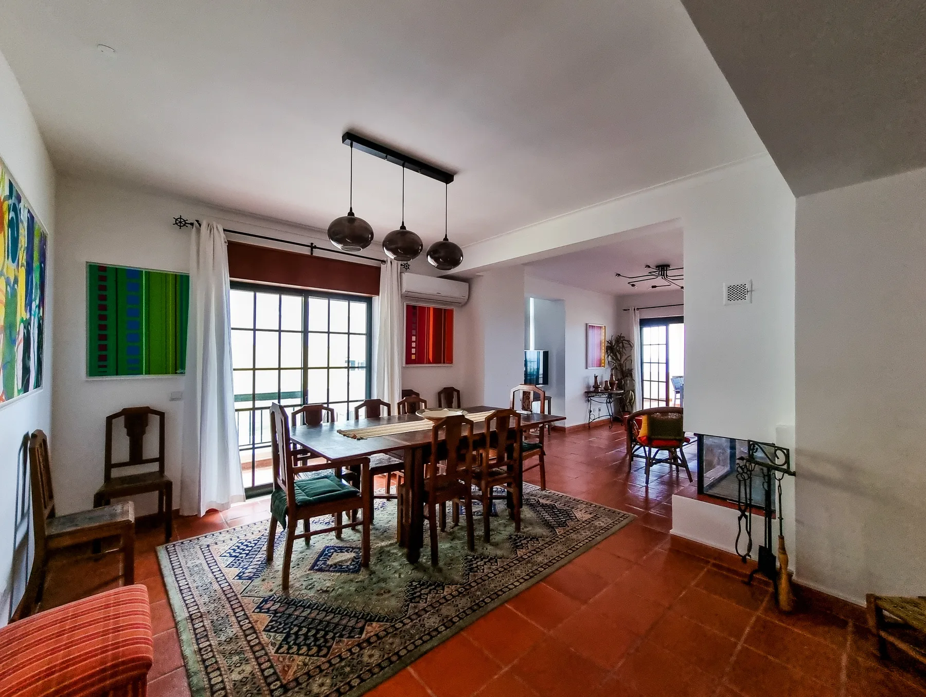 A dining area with a wooden table and chairs beside a bright window.