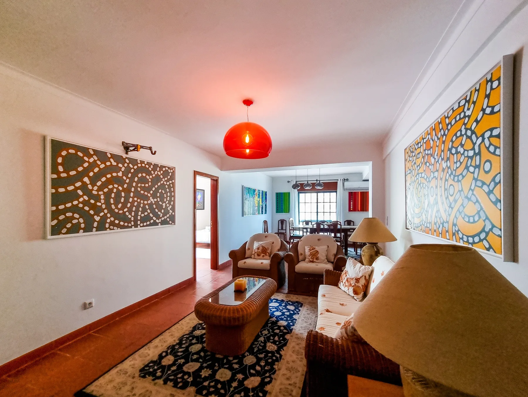 A living room with seating, patterned rugs, and colorful wall art.