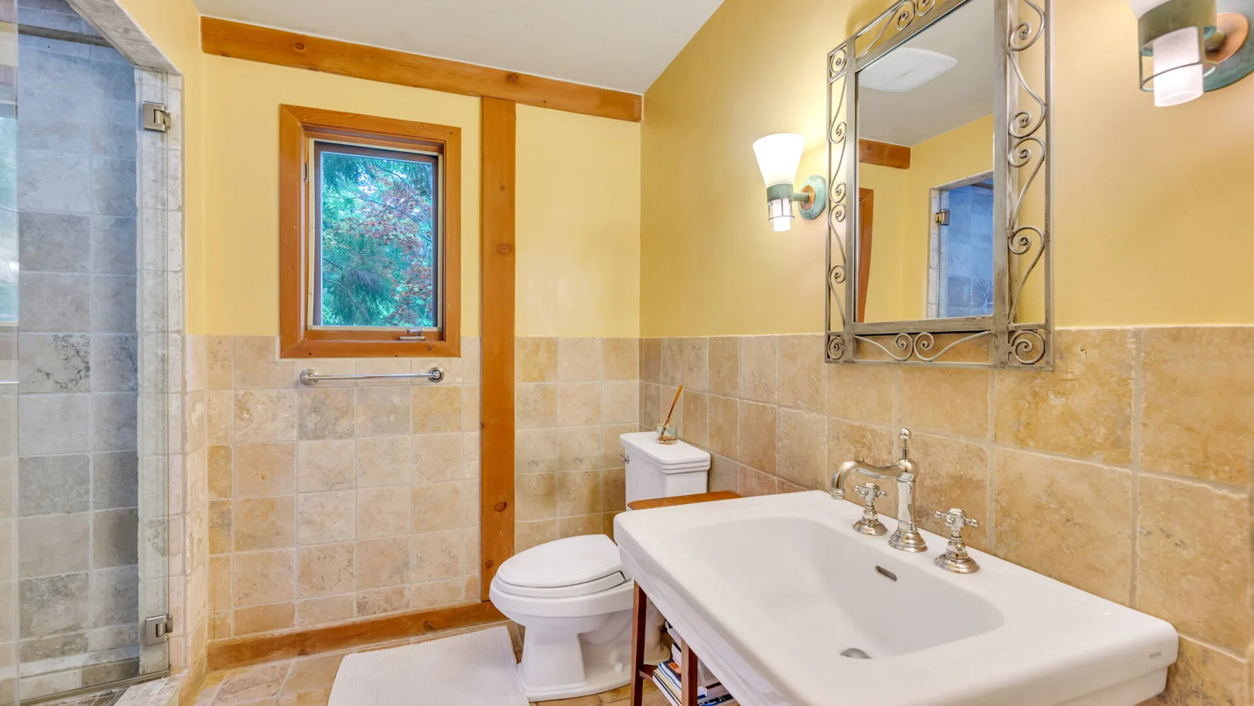 Un baño con bañera, inodoro y espejo de pared.