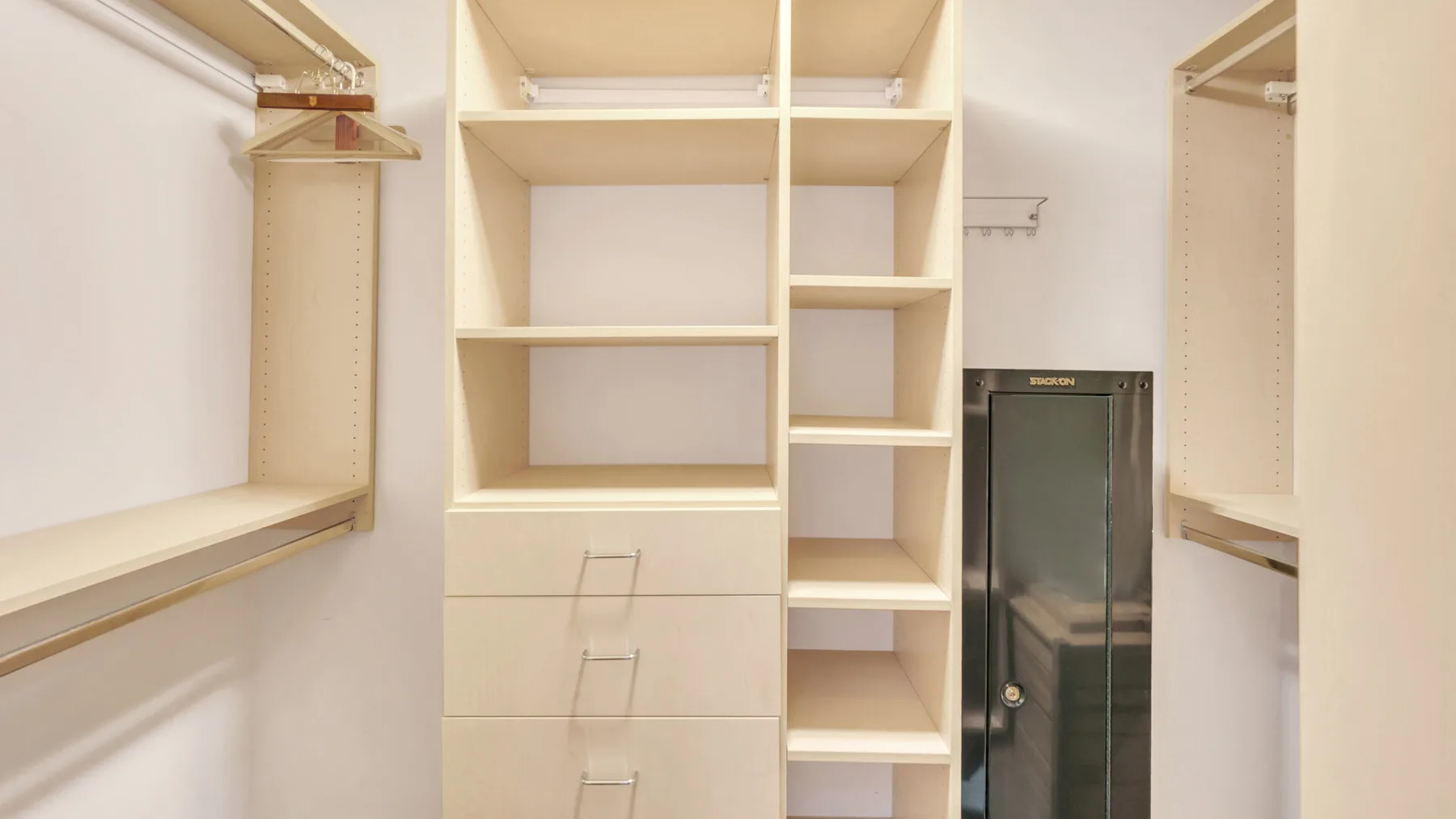 Un vestidor con estantes abiertos, cajones y espacio para colgar ropa.