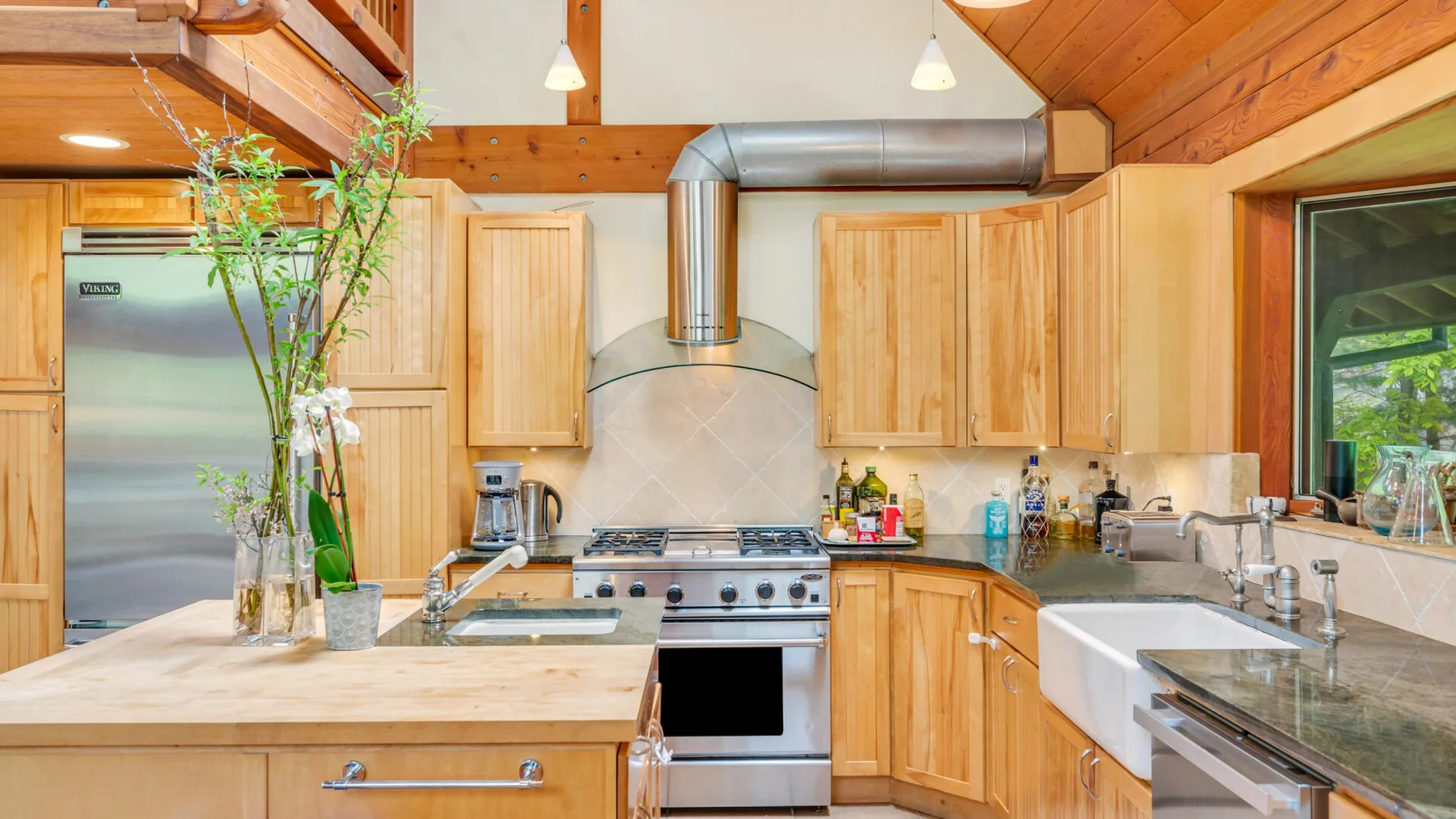 Una cocina revestida de madera con encimeras, armarios y una cocina de acero inoxidable.