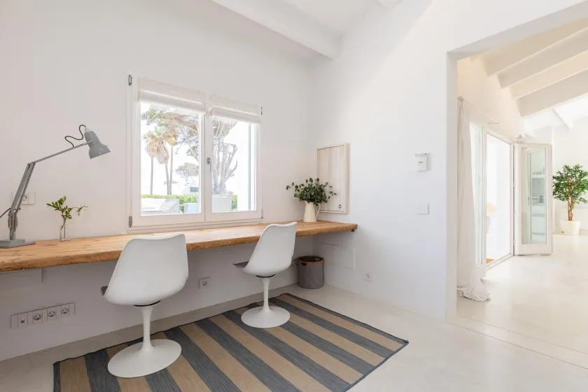 A bright workspace with two seats at a long desk beside a window.