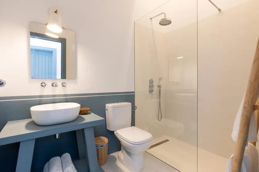 A modern bathroom with a vanity, toilet, and glass shower.
