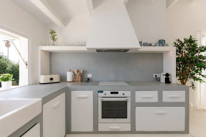 A bright modern kitchen with gray counters and a built-in oven.