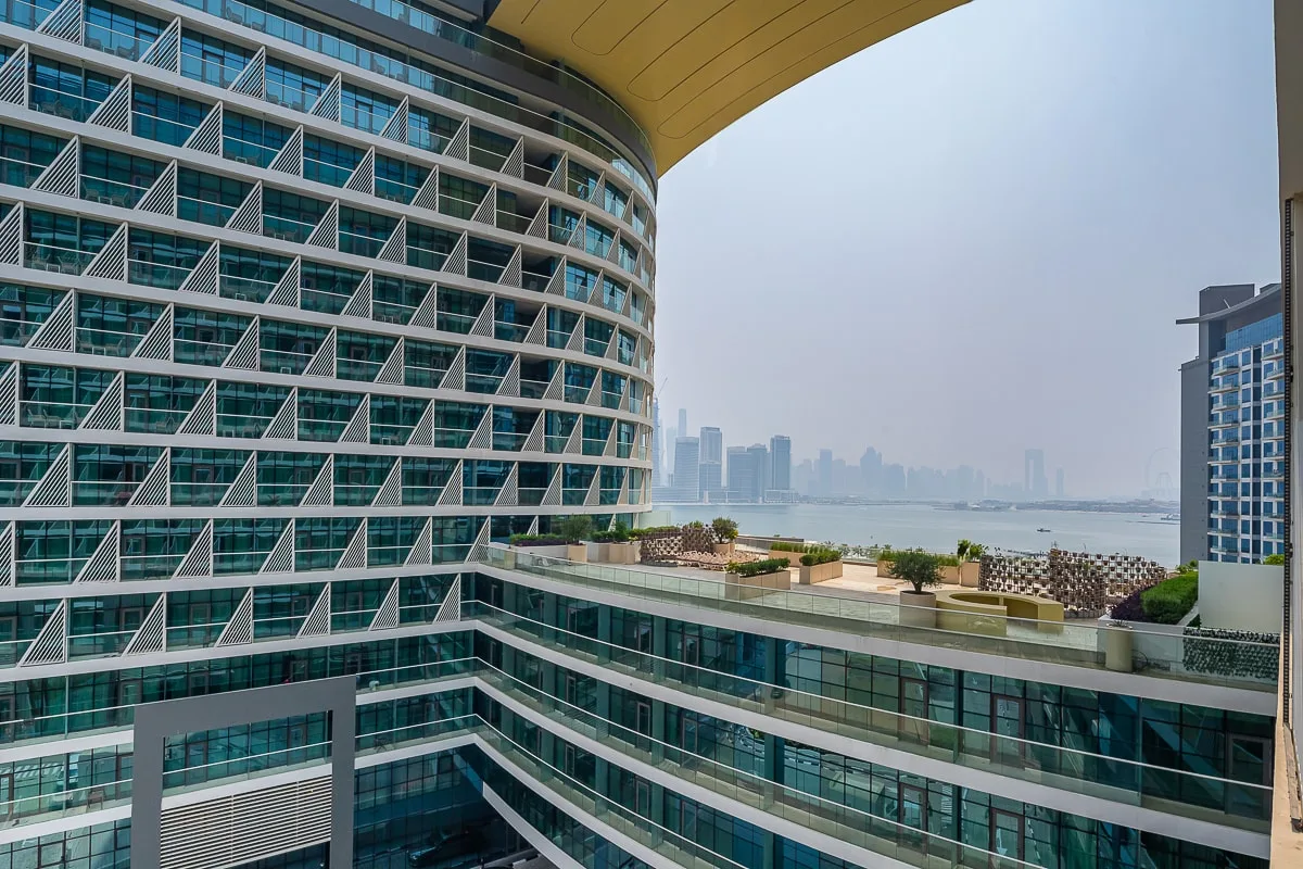 Modern high-rise buildings frame a view of the waterfront and distant skyline.